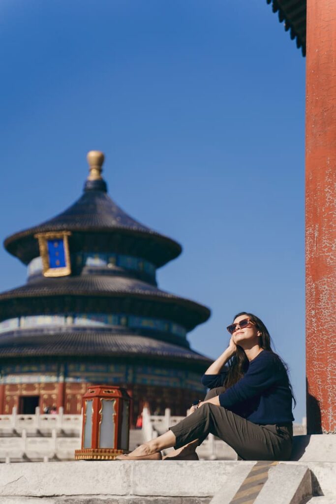 Girl taking the sun in front of a temple in Beijing in China